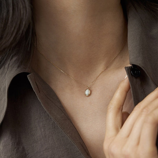 Necklace with a pendant worn by a person, focusing on the jewelry.
