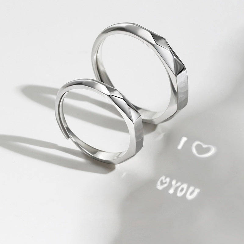 A pair of Jingqian S925 Sterling Silver Light Reflection Rings featuring a geometric design, positioned on a white surface. Light shining through the adjustable rings casts a shadow that reads "I â™¥ YOU" on the surface, with the heart shape symbolizing the word "love.