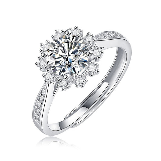Silver ring with a large central diamond and smaller diamonds on the band against a white background